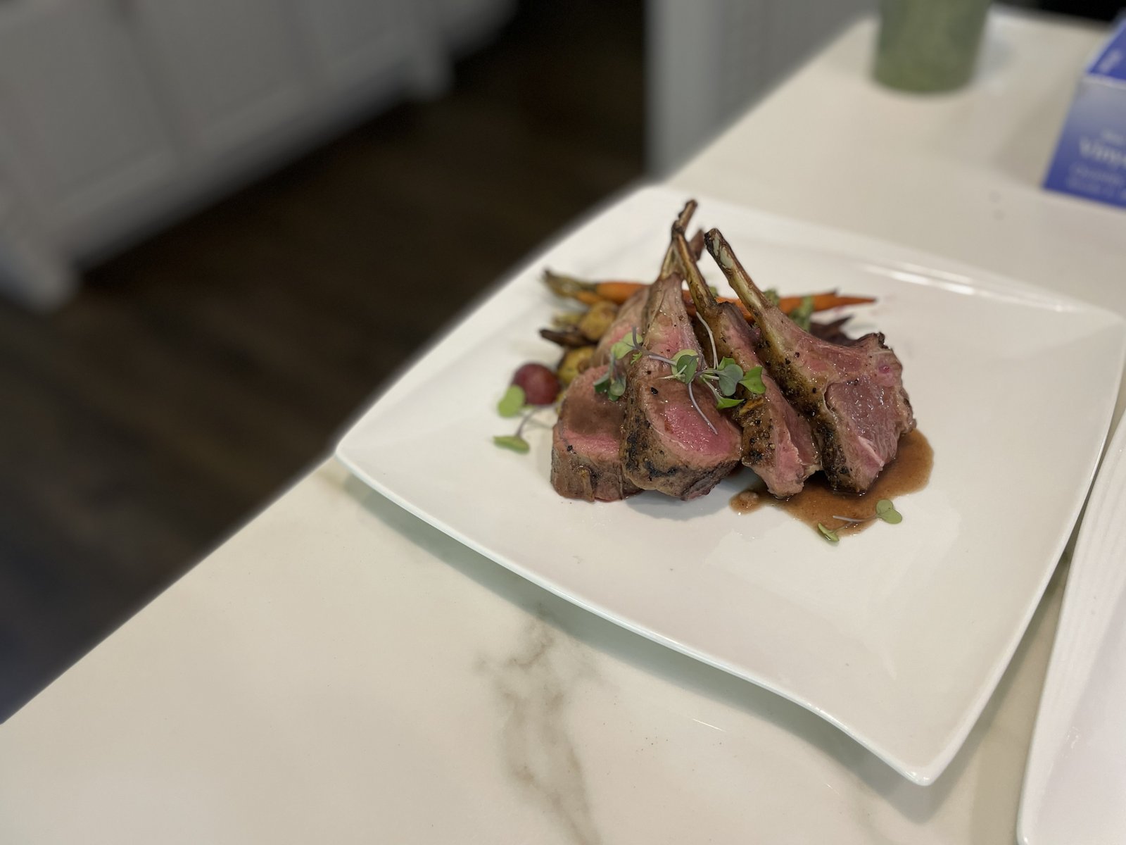 Roasted lamb chops arranged on a white plate